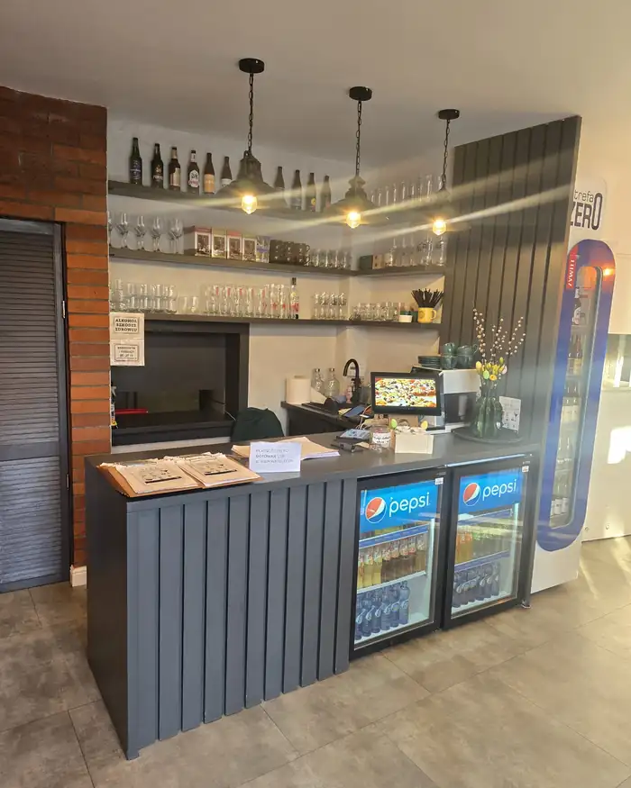 Ciemny bar z półkami na szkło i lodówką z napojami