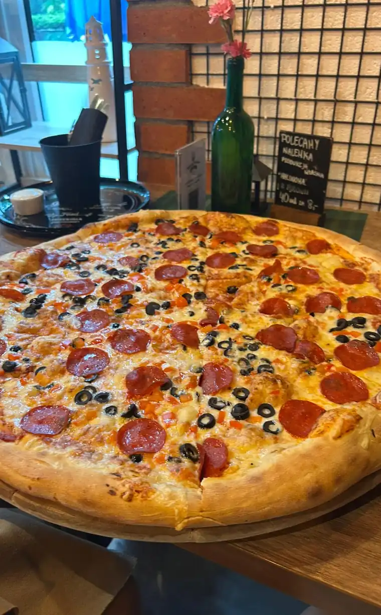 Pizza z salami prosto z pieca na drewnianym stole w Usteckiej Przystani